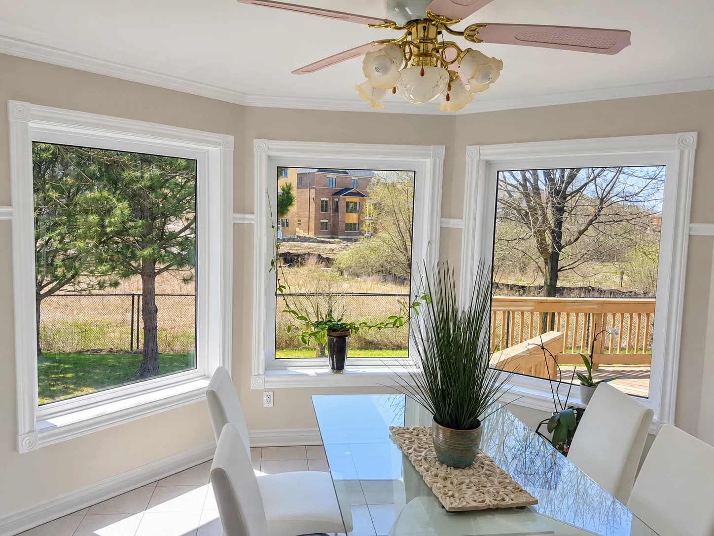 White bay windows overlooking the garden from a dining room