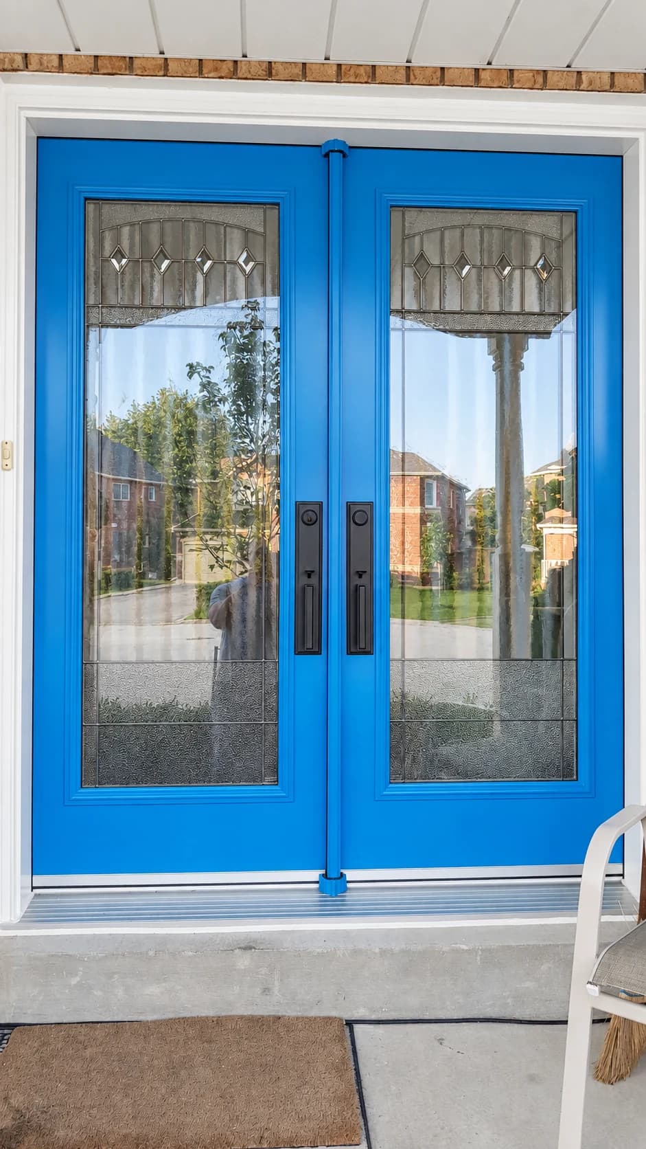 Blue double entry doors with decorative glass and black handles