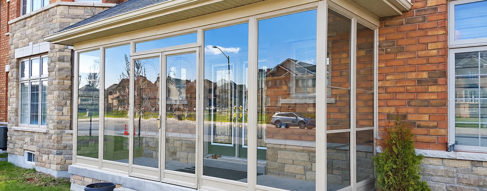White-framed glass porch enclosure with double entrance doors