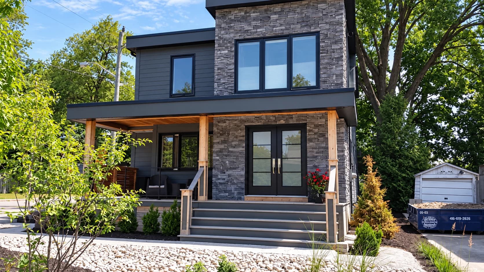 Contemporary grey home with black-framed windows and a wood-lined porch
