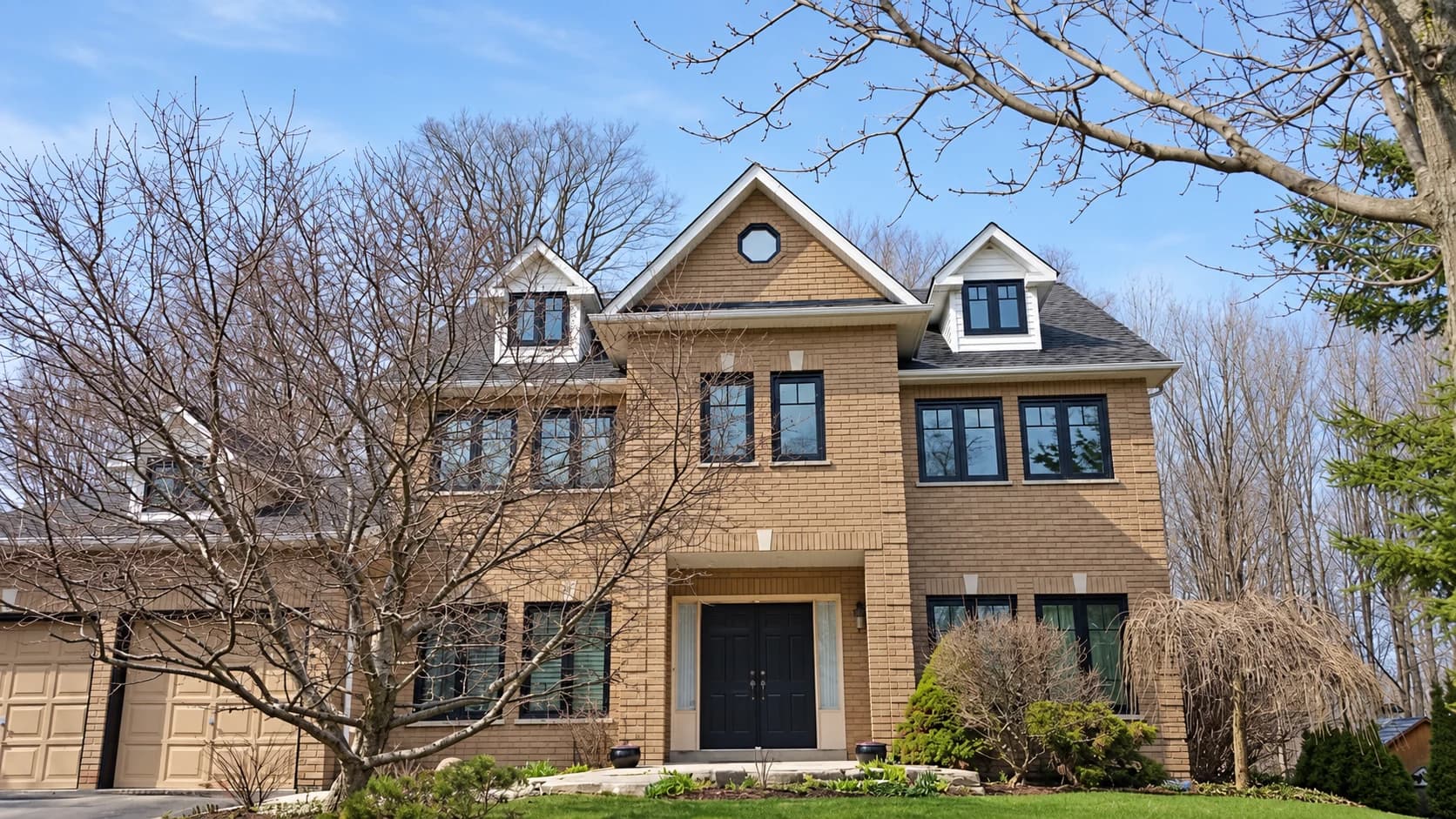 Gabled brick home with black-framed windows and an octagonal accent window