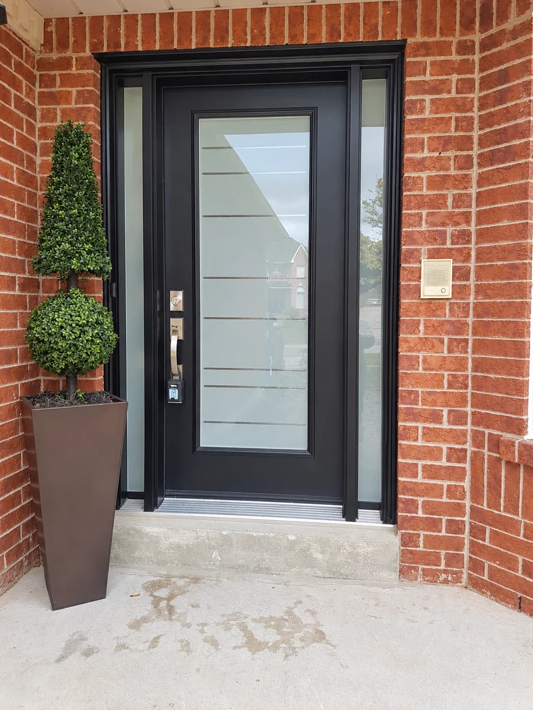 Black front entry door with frosted glass panels and matching sidelights